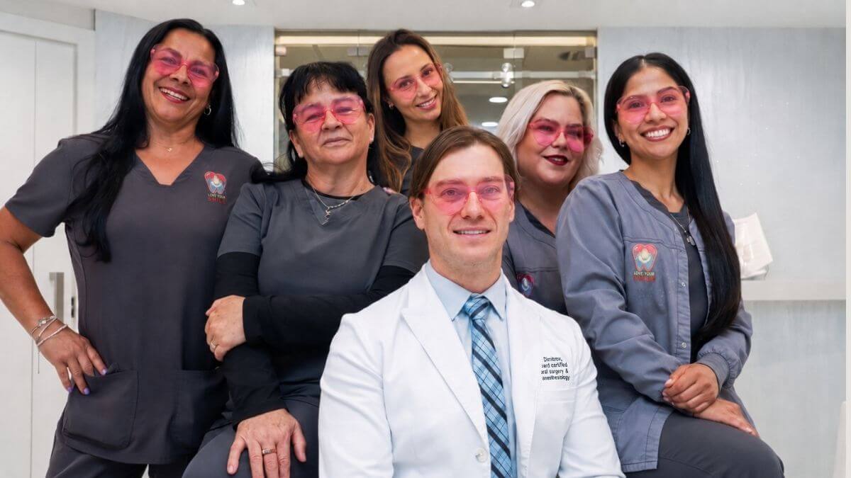 Dr. Kroum Dimitrov, a board-certified oral surgeon, and his oral surgery team at Love Your Jaws Surgery Center in South Miami smiling in pink safety glasses.