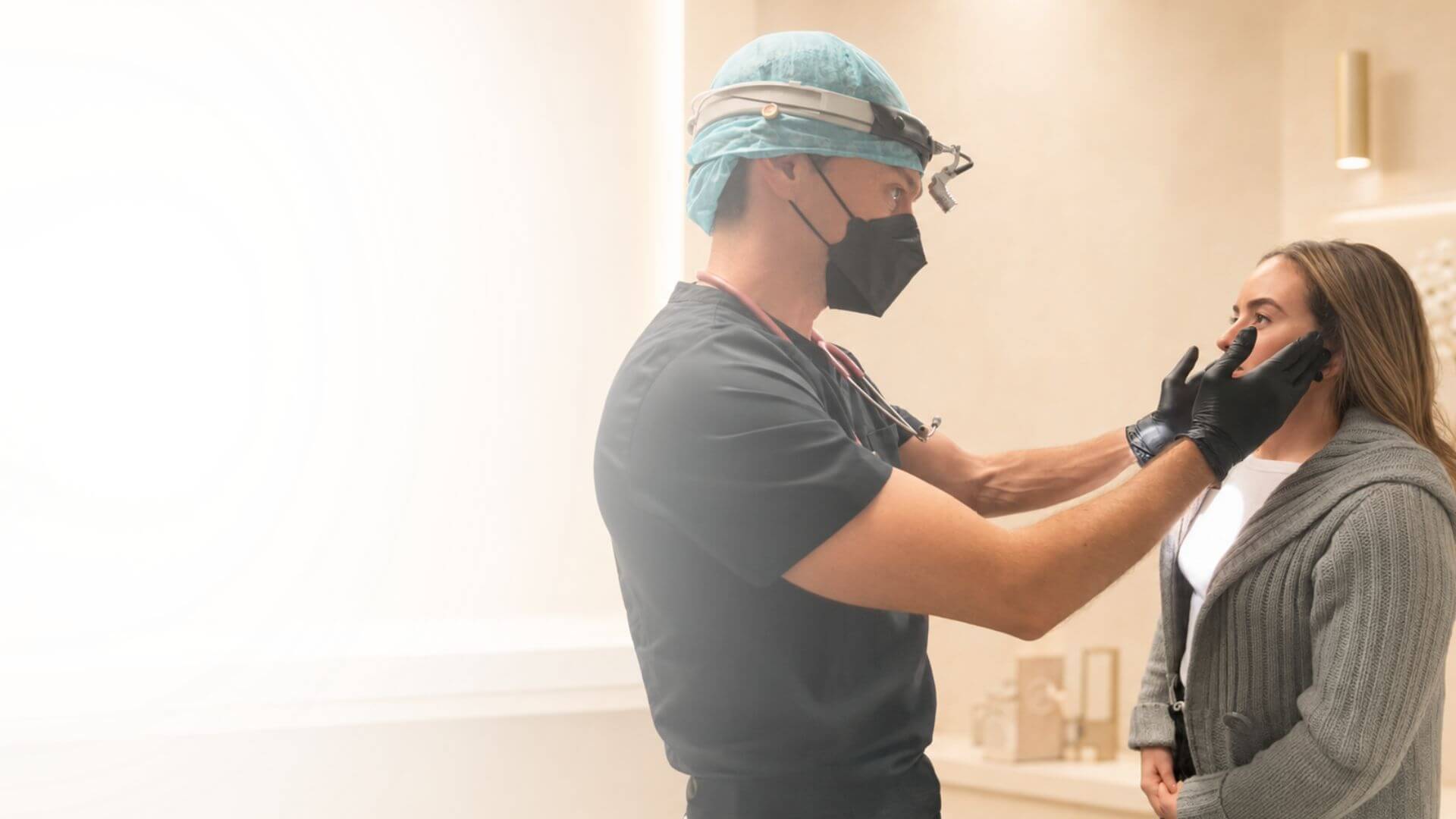 Miami oral surgeon examining a patient’s jaw during a consultation at Love Your Jaws Surgery Center.